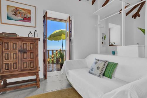 a living room with a white couch and a window at Casa de Teja in La Orotava