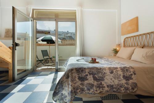 a bedroom with a bed and a balcony with an umbrella at Blue Oasis in El Cotillo