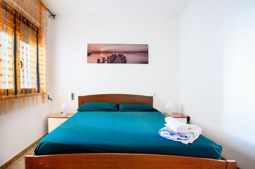 a bedroom with a bed with blue sheets and towels at Dimora Giusy in Otranto
