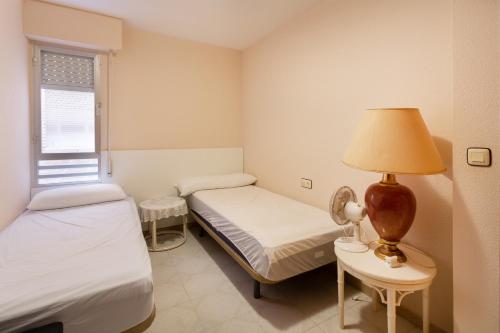 a room with two beds and a lamp on a table at Navgts5p33-1 in Torrevieja