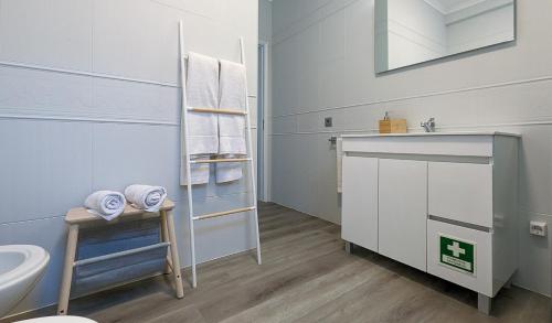 a white bathroom with a sink and a toilet at Costa Nova Ocean View in Gafanha da Encarnação