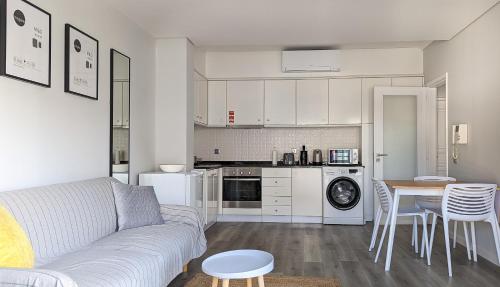 a living room with a couch and a table and a kitchen at Costa Nova Ocean View in Gafanha da Encarnação
