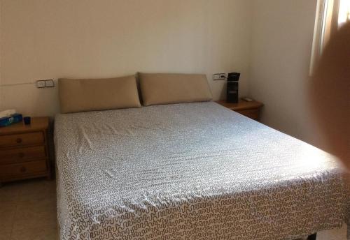 a bedroom with a bed with a white bedspread at Casa Cuesta in Bolnuevo