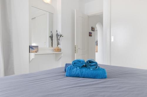 a blue towel with two blue roses on a bed at Stunning Sunset Ocean View Apt in Taurito