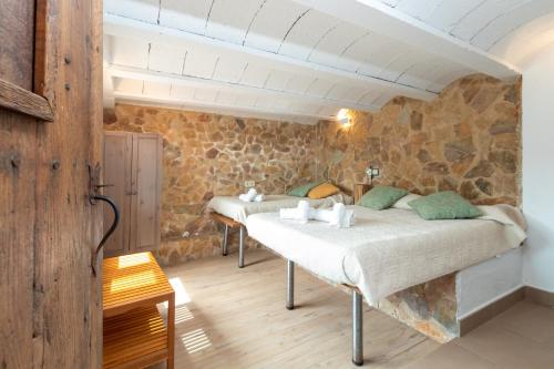 a bedroom with two beds in a stone wall at Espectacular villa en Begur in Begur
