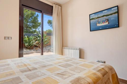 a bedroom with a bed and a large window at Casa Tico in Roda de Bará