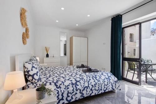 a bedroom with a blue and white bed and a balcony at Amazing Oura Beach Apartment in Albufeira