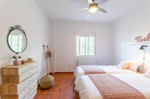 a bedroom with a bed and a mirror and a dresser at Casa Arco Iris in Cómpeta