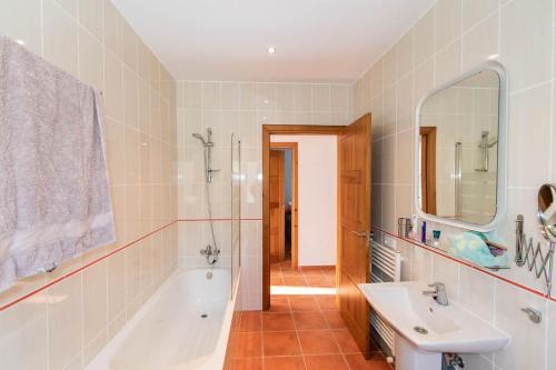 a bathroom with a tub and a sink and a shower at Casa Arco Iris in Cómpeta