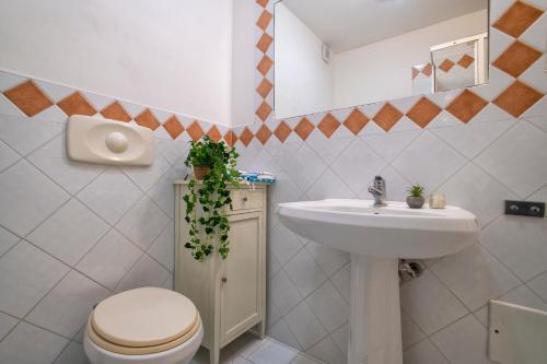 a bathroom with a toilet and a sink at Villa Azzurra in Stintino