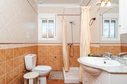 a bathroom with a toilet and a sink and a shower at Las Alas del Sol in Vejer de la Frontera