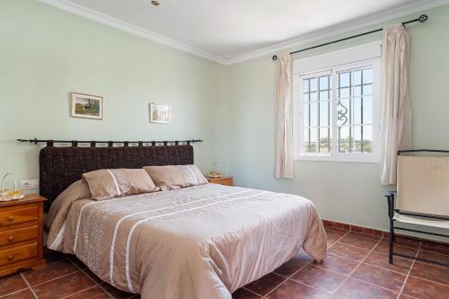 a bedroom with a large bed and a window at Las Alas del Sol in Vejer de la Frontera