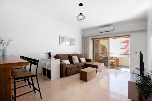a living room with a couch and a table at Brisa Salina D'Alporchinhos in Armação de Pêra