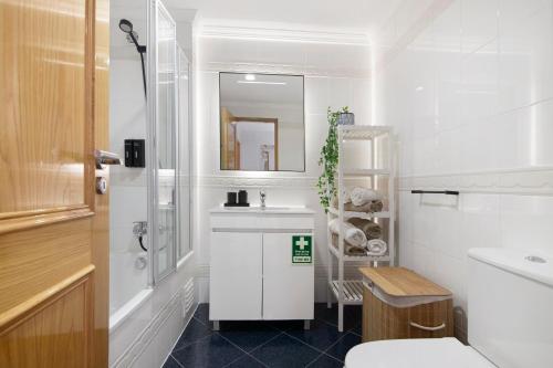 a white bathroom with a sink and a toilet at Brisa Salina D'Alporchinhos in Armação de Pêra