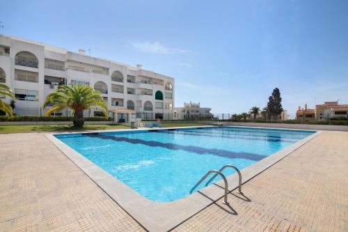 a swimming pool in front of a building at Brisa Salina D'Alporchinhos in Armação de Pêra