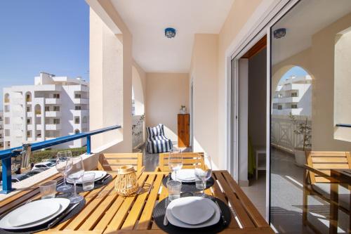 a dining room with a table and a balcony at Brisa Salina D'Alporchinhos in Armação de Pêra