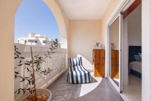 a balcony with a blue and white pillow and a vase at Brisa Salina D'Alporchinhos in Armação de Pêra