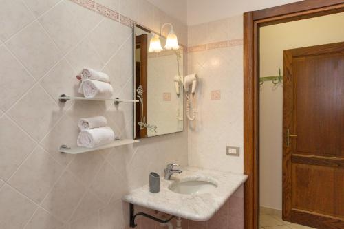 a bathroom with a sink and a mirror and towels at Il Girasole - Mirto in Venturina Terme