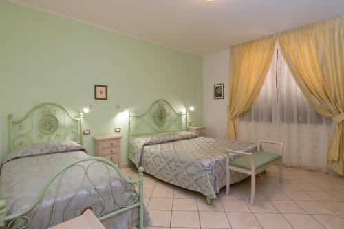 a bedroom with two beds and a window at Il Girasole - Mirto in Venturina Terme