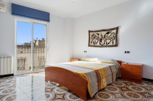 a bedroom with a bed and a large window at La Garrofera in Aldover