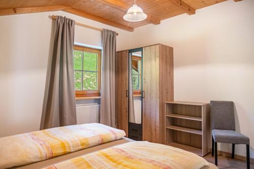 a bedroom with a bed and a chair and a window at Oberpatiglhof - Lukas in Brie