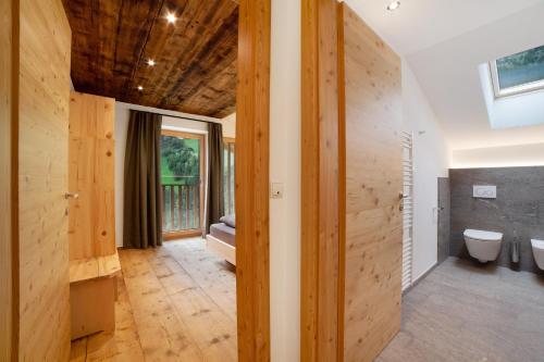 a bathroom with wooden walls and a toilet and a window at Herrischner Apartement 1 in Moso