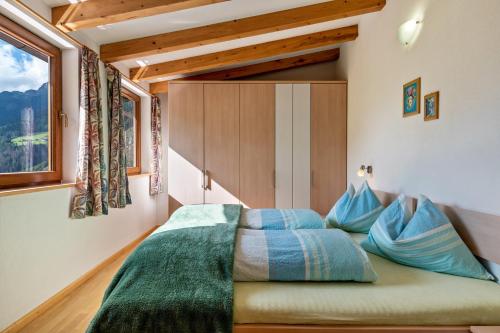 a small bedroom with a bed with blue pillows at Glocklechnhof Sternenhimmel in Cadipietra