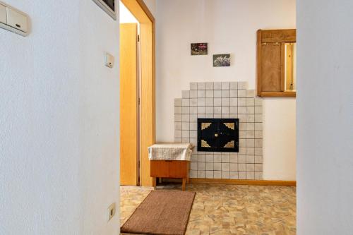 a room with a tile fireplace and a doorway at Glocklechnhof Sternenhimmel in Cadipietra