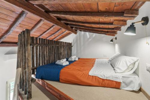a bedroom with a bed in a room with wooden ceilings at Luxar Suites and Apartments in Assemini