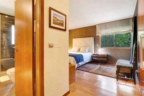a hotel room with a bed and a bathroom at Casa dos Pinheiros in Apúlia