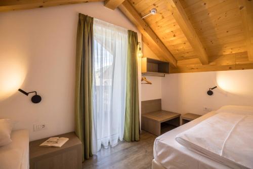 a bedroom with a bed and a large window at Apartment Ot Residence Bun Sté in San Vigilio Di Marebbe