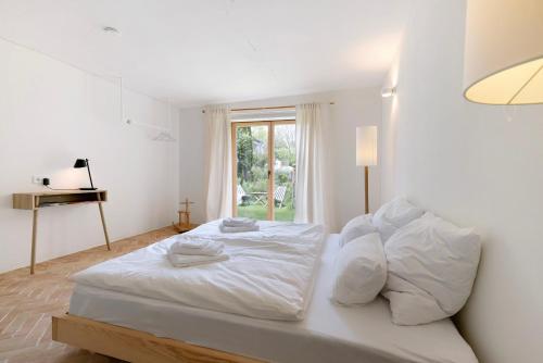 a white bed in a room with a window at Im Gräbele in Rosenfeld
