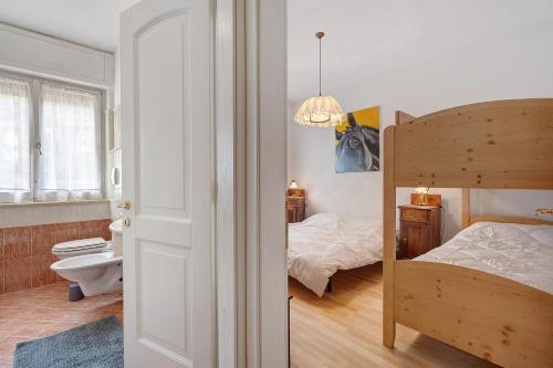 a bedroom with a bunk bed and a bathroom at Casa Marta in Cavalese