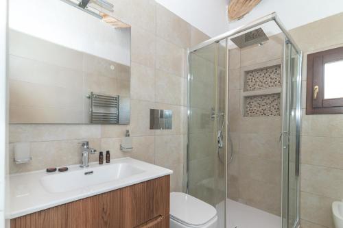 a bathroom with a toilet and a sink and a shower at Villetta Nicola in Olbia