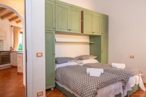 two beds in a room with green cabinets at Villetta Nicola in Olbia