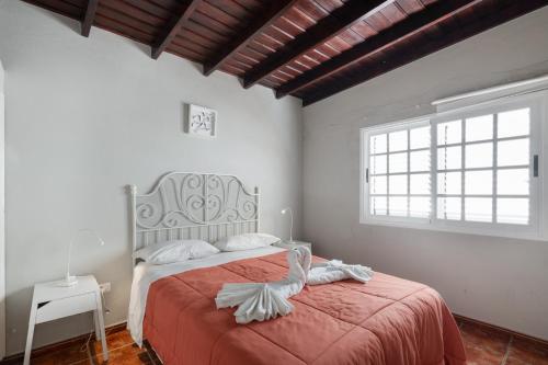 a bedroom with a large bed with a red blanket at Los Lilos in Tijarafe
