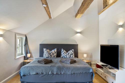 a bedroom with a bed and a flat screen tv at Hof Rosenstein in Helle