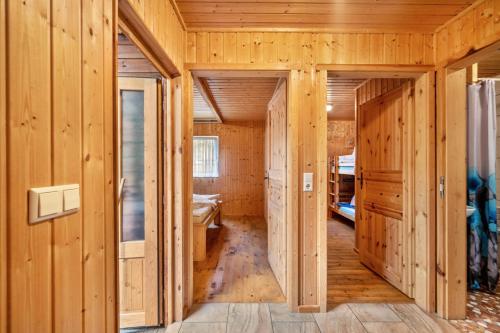 a hallway of a wooden house with wooden walls at Bungalow 18 - Finnhütte in Niesky