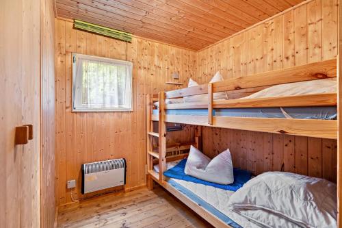 a bedroom with two bunk beds in a wooden cabin at Bungalow 18 - Finnhütte in Niesky