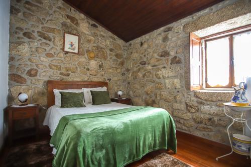 a bedroom with a bed in a stone wall at Casa Da Calçada - Turismo Sortelha in Sortelha