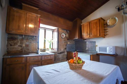 a kitchen with a basket of fruit on a table at Casa Da Calçada - Turismo Sortelha in Sortelha
