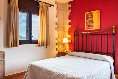 a red bedroom with a bed and a window at El Rincón Del Duende in Pedro Bernardo