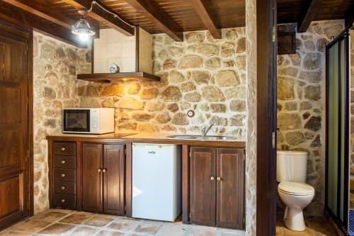 a kitchen with a white refrigerator and a microwave at El Rincón Del Duende in Pedro Bernardo