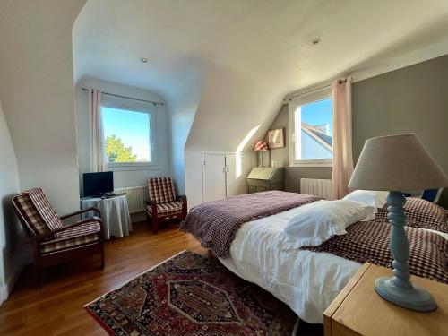 a bedroom with a bed with a lamp and two chairs at Chambres Er Vingle - Locmariaquer in Locmariaquer
