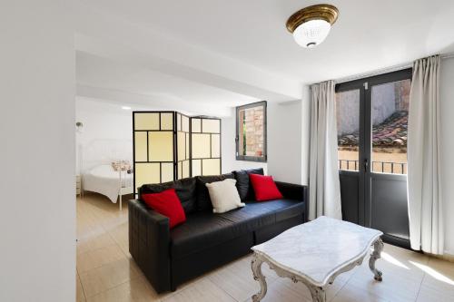 a living room with a black couch and a table at Wonderful loft centre Manresa in Manresa