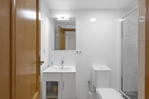 a white bathroom with a sink and a shower at Wonderful loft centre Manresa in Manresa