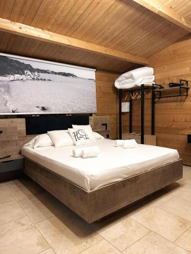 a large bed in a room with a large window at Les Chalets De Tesa 4 in Occhiatana