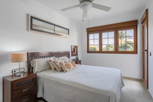 a bedroom with a bed and a ceiling fan at Casa en la playa con piscinas A in Puerto Marino