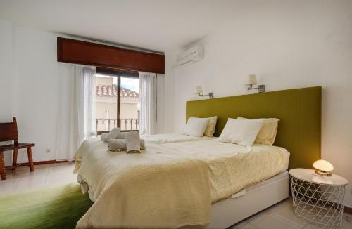 a bedroom with a large bed with a green headboard at La Casa de Manuel in Estepona