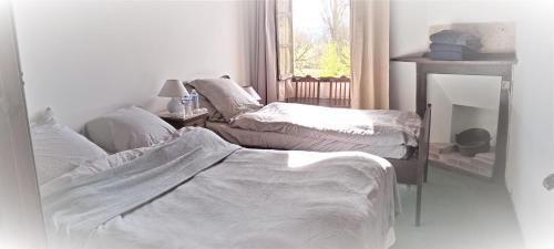 a living room with two beds and a window at La Maison Chez Karen in Séniergues